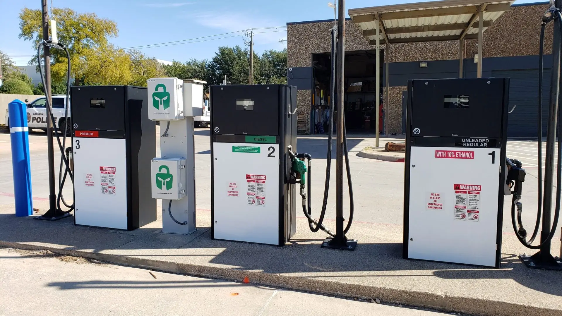 Three gas pumps at a refueling station.
